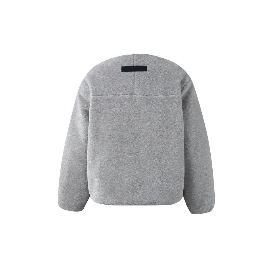 Back of a light gray fleece jacket, with a yoke seam and small black tab near the collar.