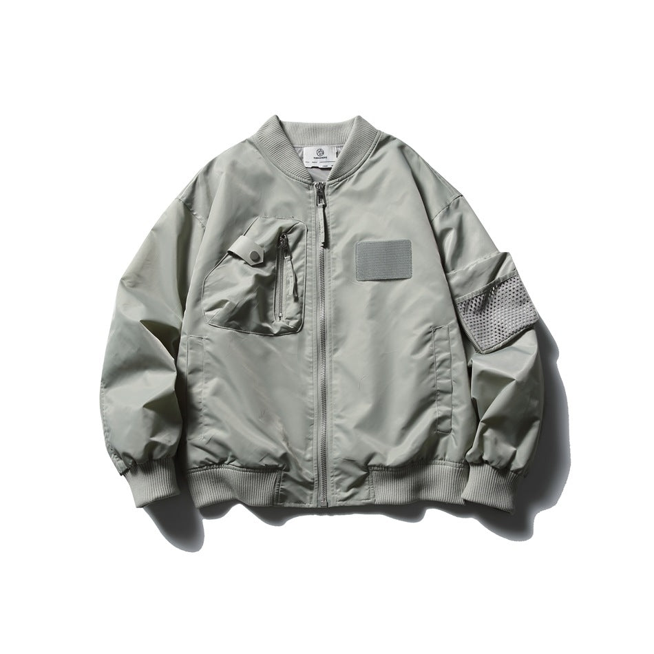 Gray bomber jacket flat lay with ribbed collar, front zipper, chest zip pocket, chest patch and mesh sleeve pocket