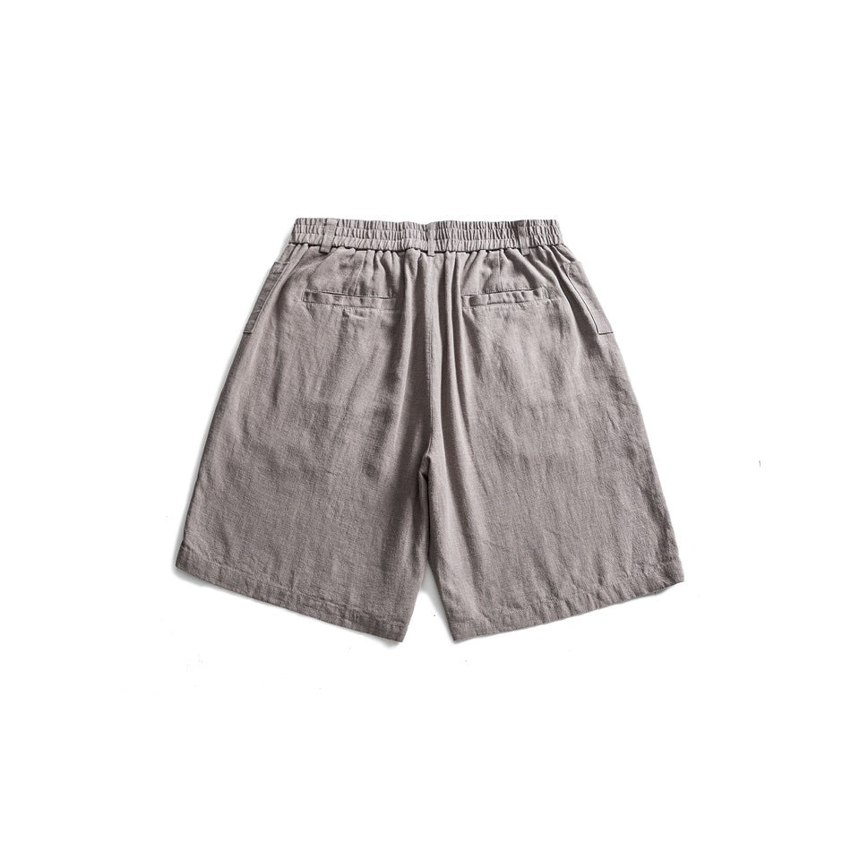 Gray shorts back view with gathered elastic waistband and two welt back pockets, flat lay