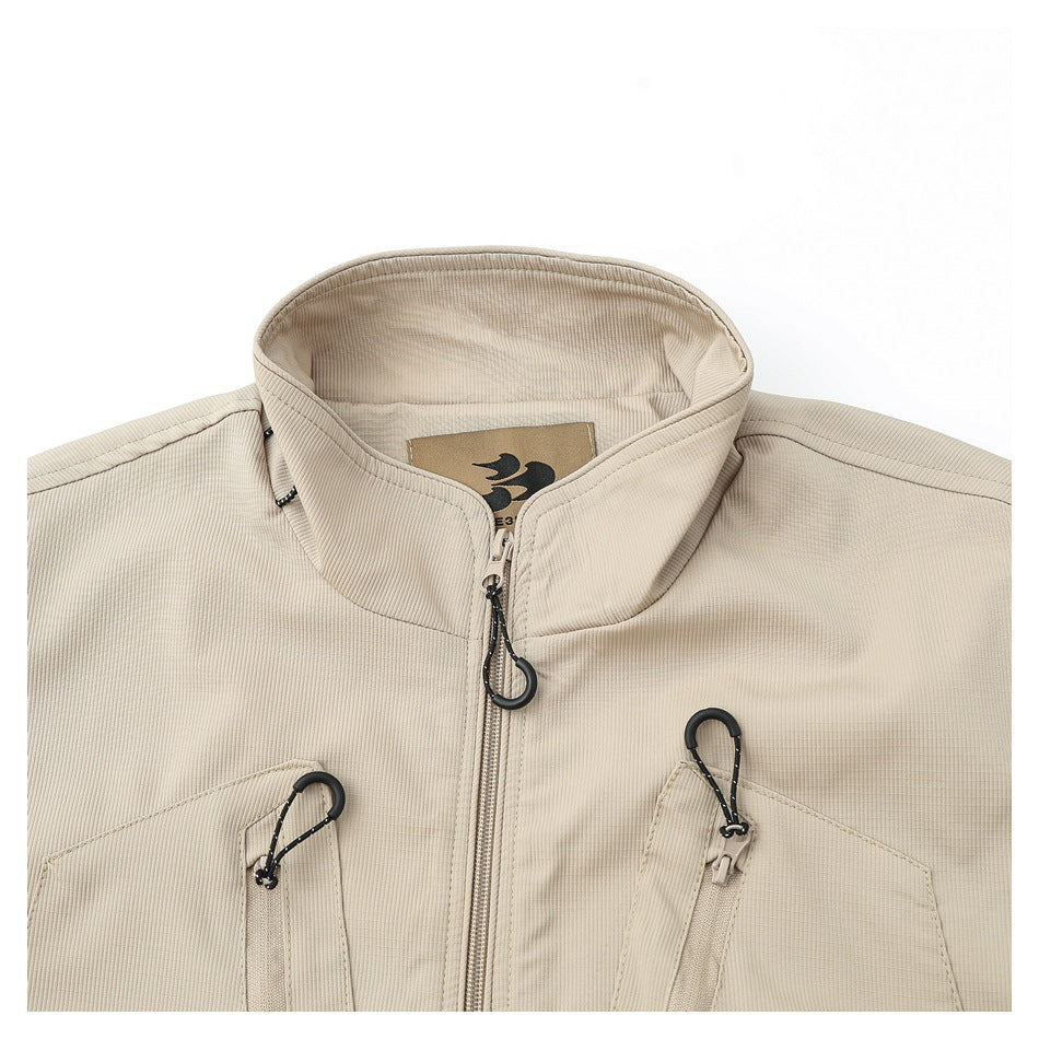 Close-up of the beige vest's stand collar, front zipper, chest pockets, and black zipper pulls.