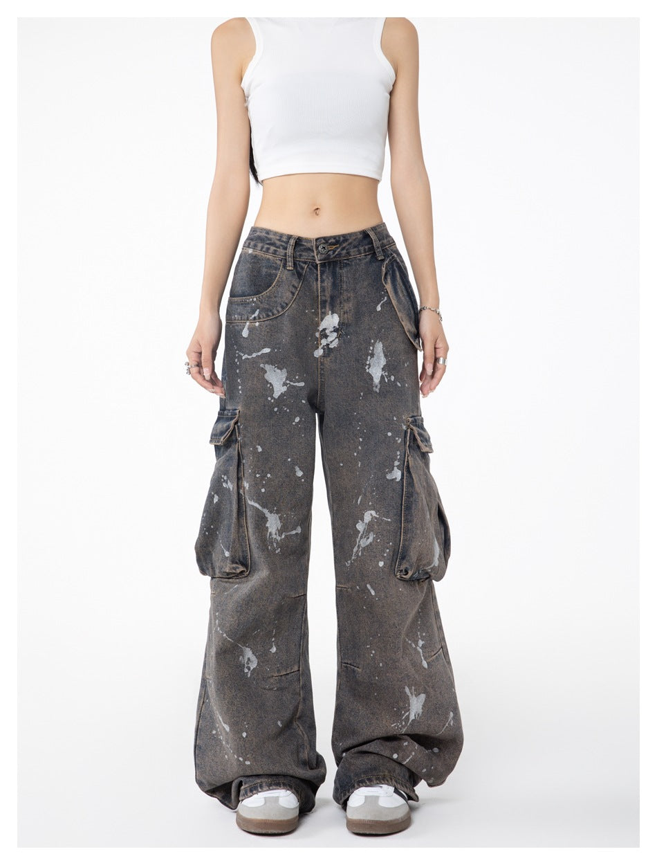Front view of a model wearing wide-leg charcoal-gray paint-splatter cargo jeans with oversized side pockets.