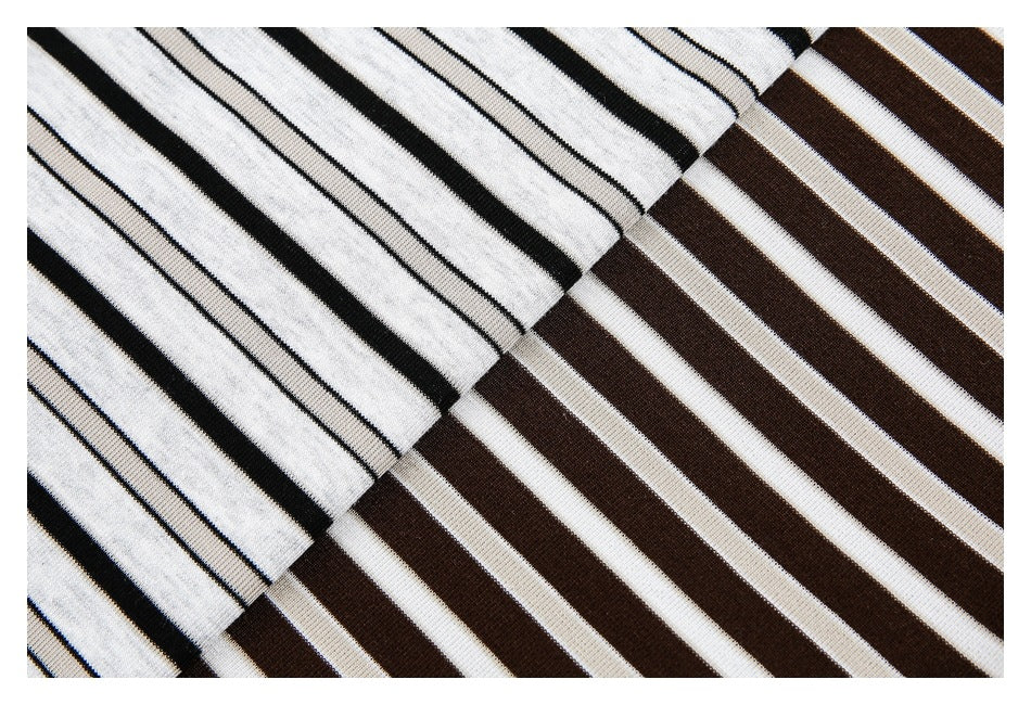 Close-up of striped T-shirt fabric in light gray with thin black stripes and dark brown with white stripes.