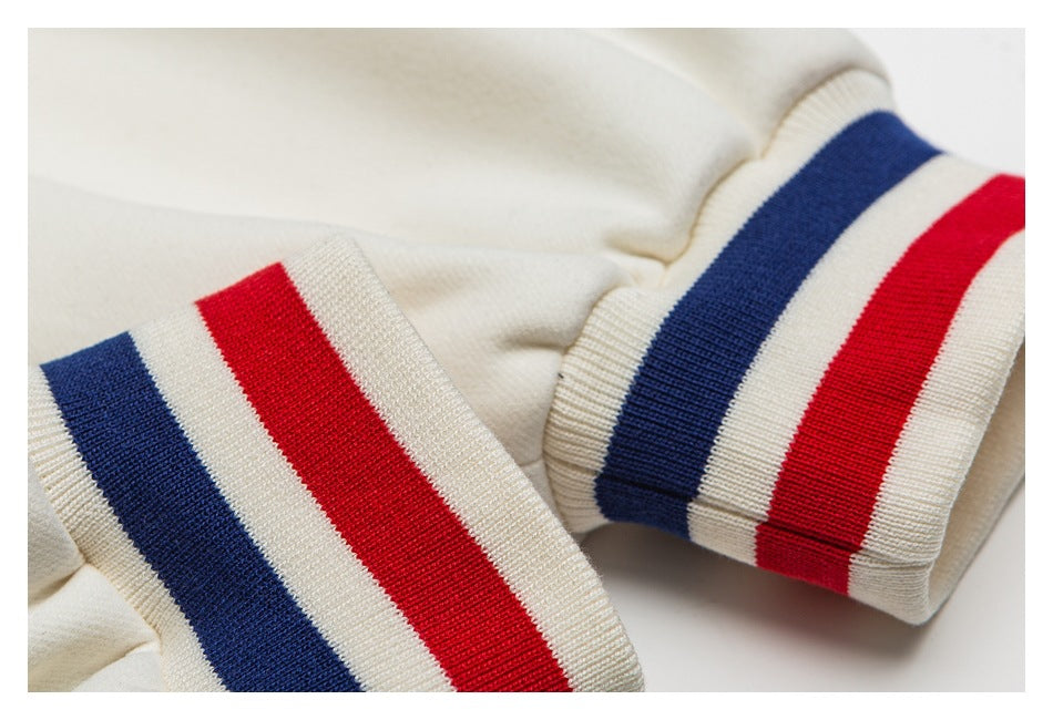 Close-up of two ivory ribbed cuffs with navy, ivory, and red stripes.