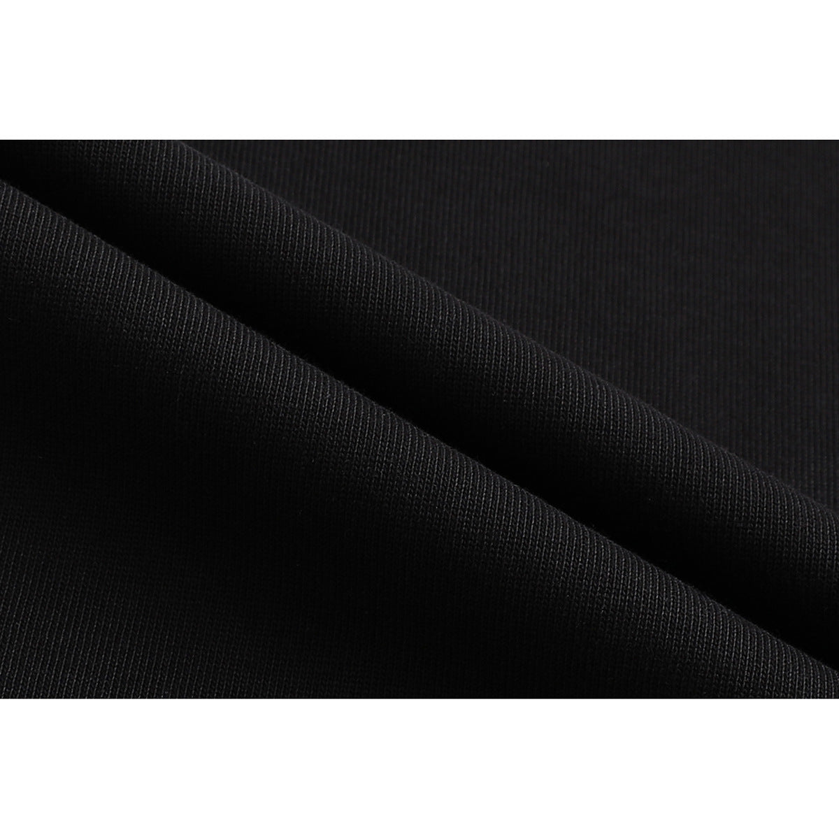 Close-up of black fabric folded to show its fine, closely spaced knit texture.