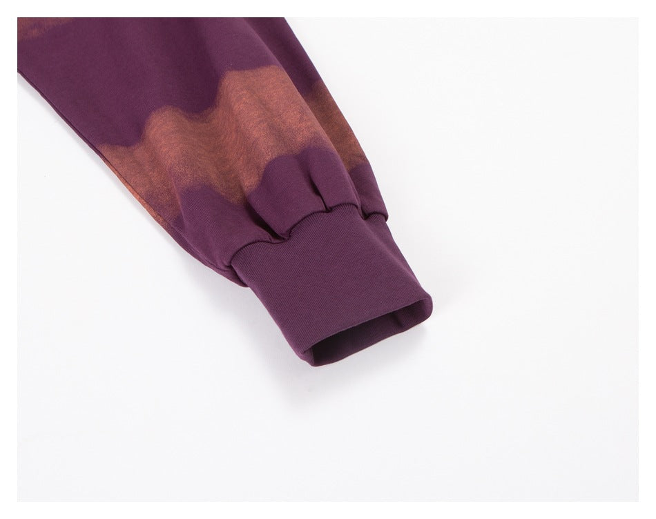 Sleeve close-up showing a plum ribbed cuff beneath a rust-brown wavy stripe.
