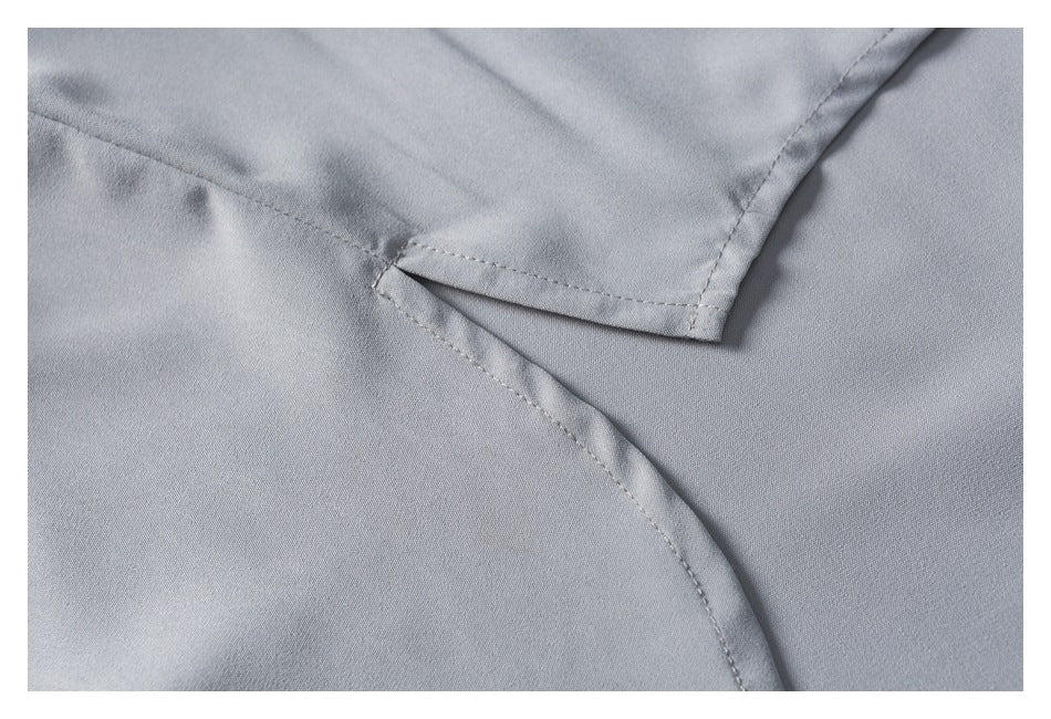 Close-up of stitching and a curved seam on light gray fabric.