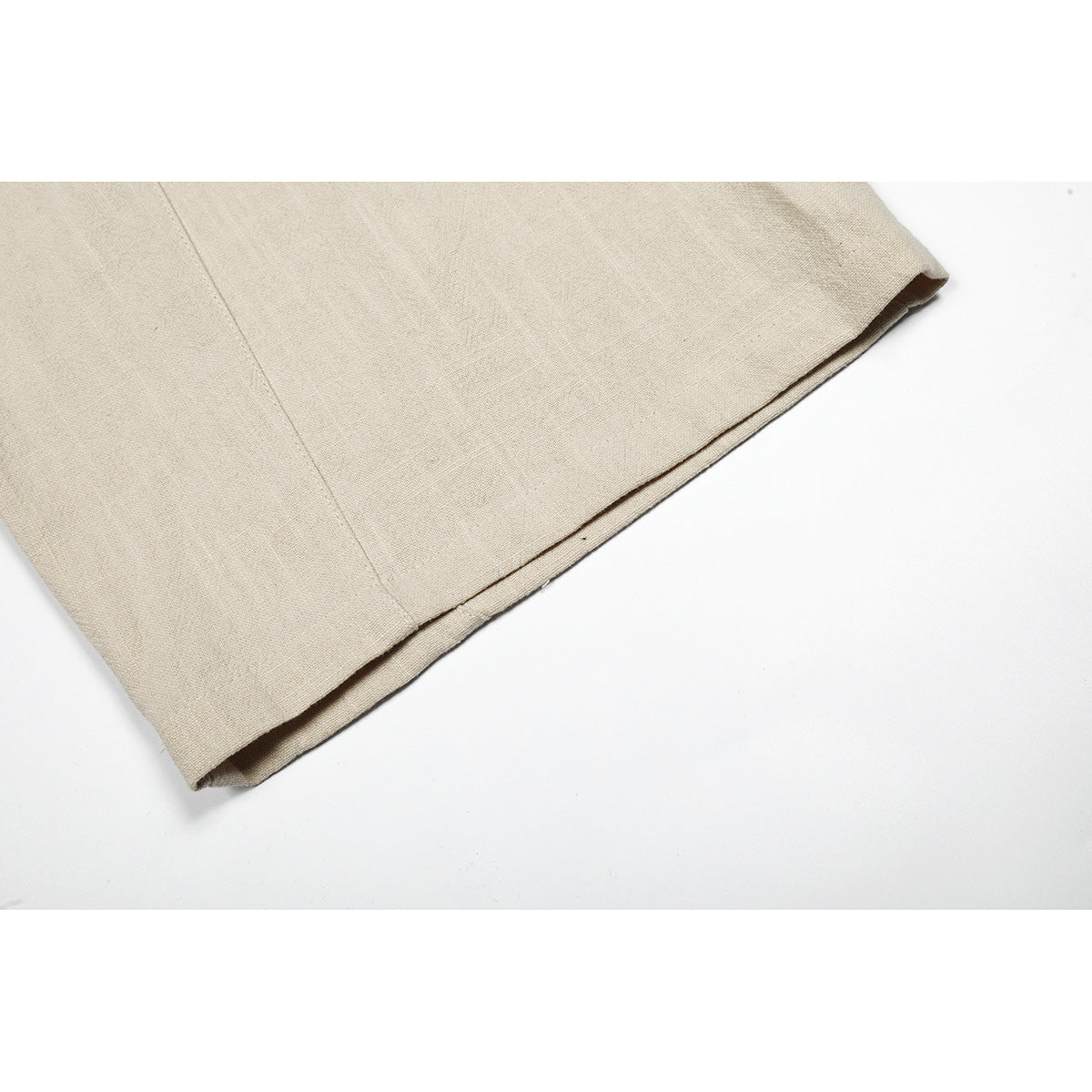Close-up of beige trouser leg showing the stitched hem and fabric texture.