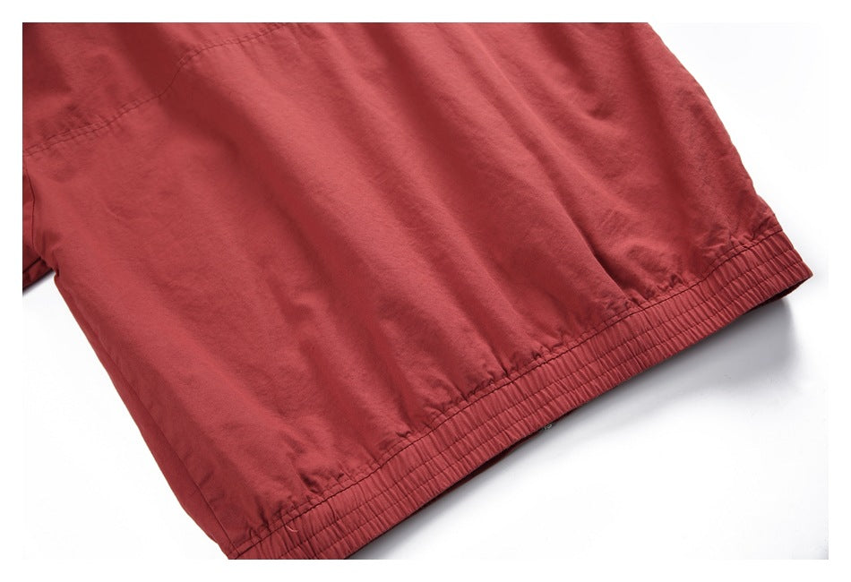 Close-up of a muted red garment with a gathered, elasticized edge and visible stitching.