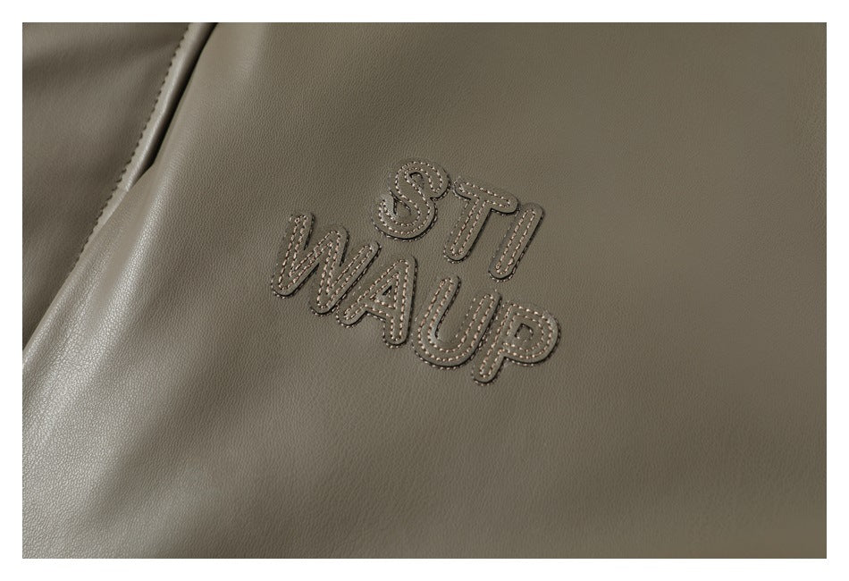 Close-up of raised tonal English lettering embroidered on the olive-gray jacket.