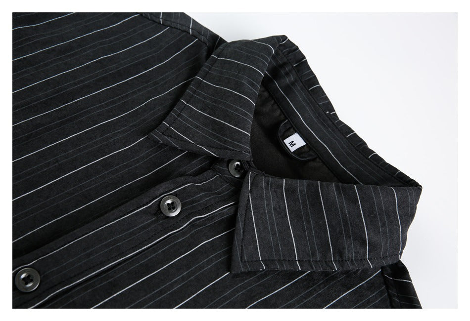 Close-up of a black shirt with thin pale stripes, showing its collar, buttons, and size M label.