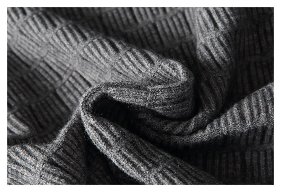 Close-up of gray textured knit fabric folded and draped to show its raised ribbed pattern.
