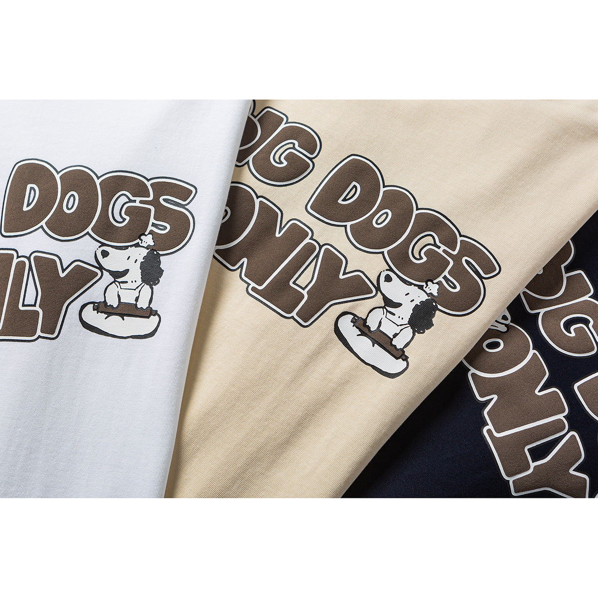 Close-up of white, pale yellow, and navy T-shirts with a brown-and-white “BIG DOGS ONLY” dog graphic.