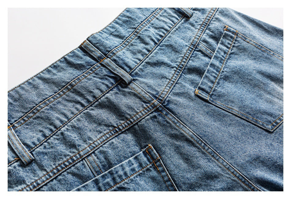 Close-up of blue jeans showing the waistband, belt loops, fly area, and front pocket.