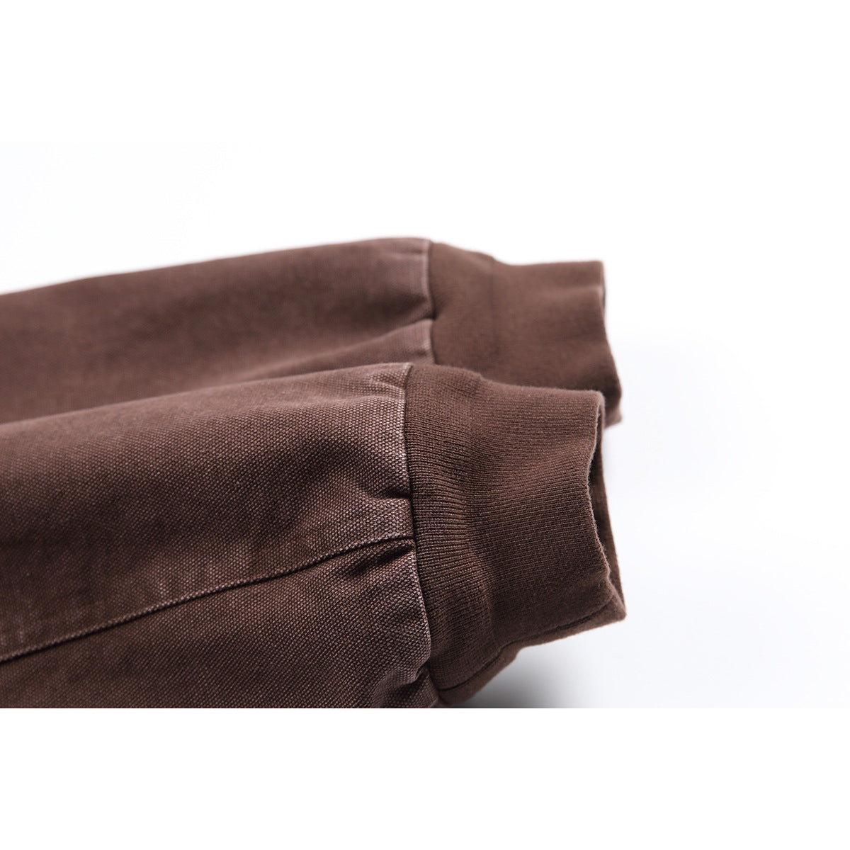 Close-up of the brown jacket's sleeve and wide ribbed cuff.