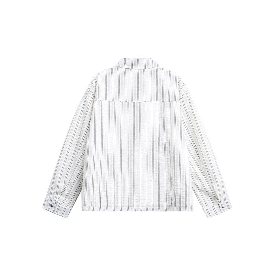 Back view of an off-white shirt with thin vertical stripes, a back yoke, long sleeves and buttoned cuffs.