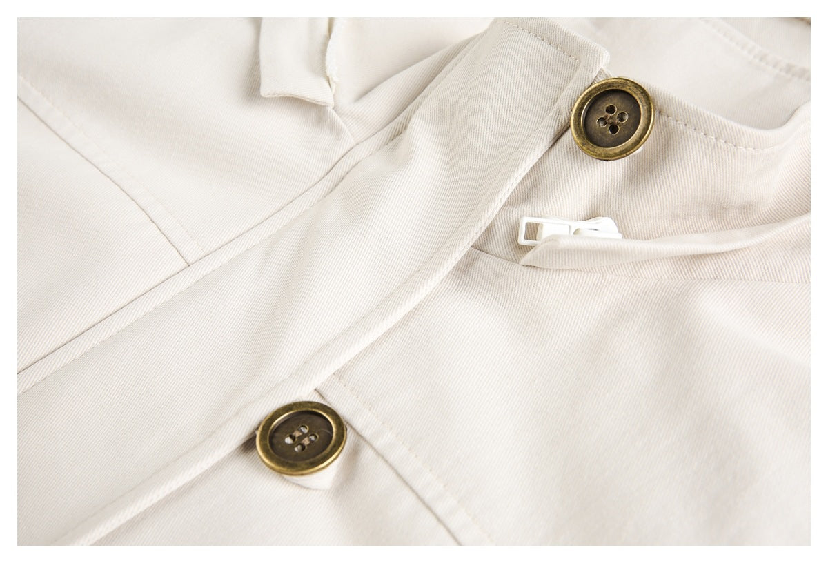 Close-up of the ivory jacket's front placket with brown buttons and a white zipper.