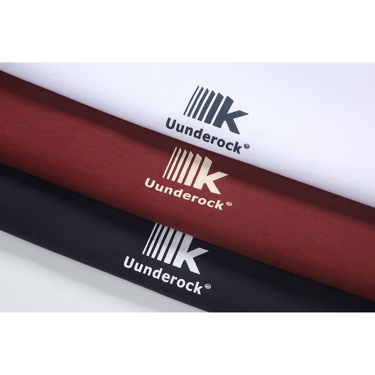 Close-up of white, burgundy, and navy fabric strips, each printed with a small white or dark logo.
