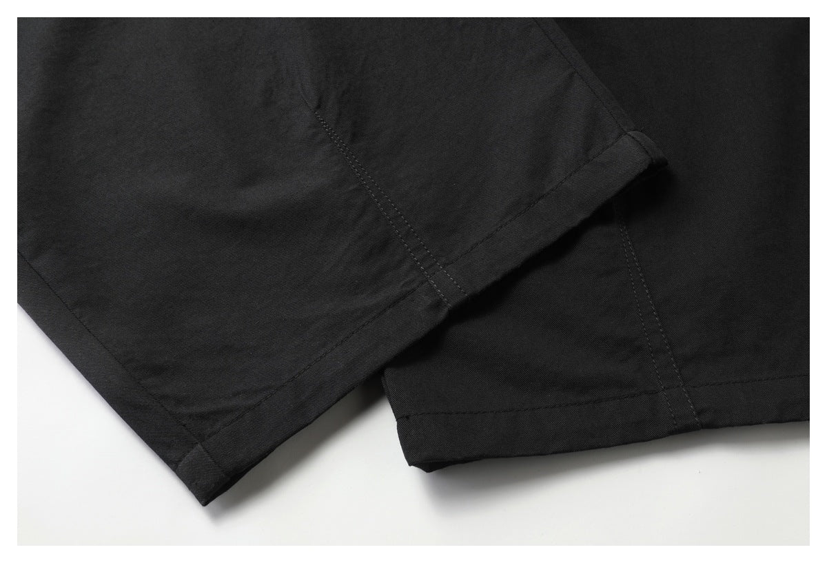 Close-up of two black garment hems with visible stitching and folded edges.