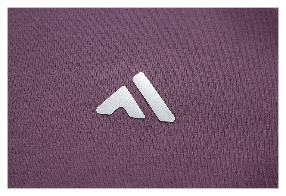 Close-up of a white angular emblem on purple fabric.