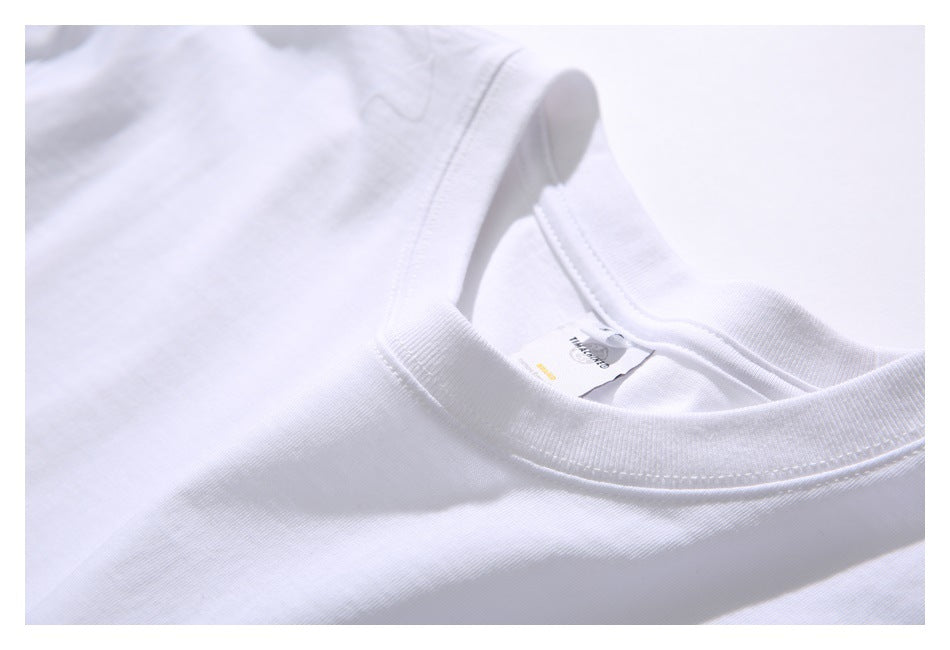 Angled close-up of a white T-shirt's ribbed crew neck, shoulder seam, and inner label.
