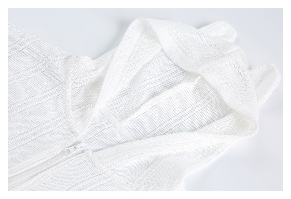 Close-up of white textured knit garment with a white zipper and overlapping fabric panels.