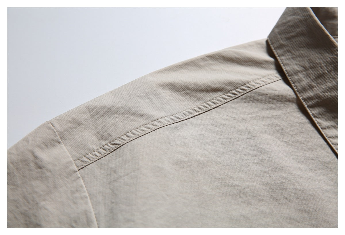 Close-up of the light beige shirt's shoulder seam and collar edge.