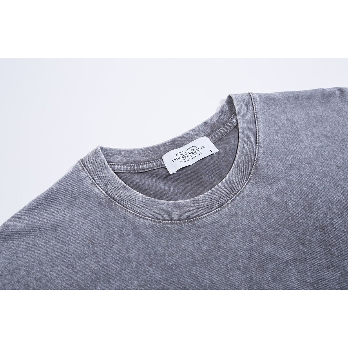 Close-up of a gray washed T-shirt’s ribbed crew neckline and sewn-in neck label.