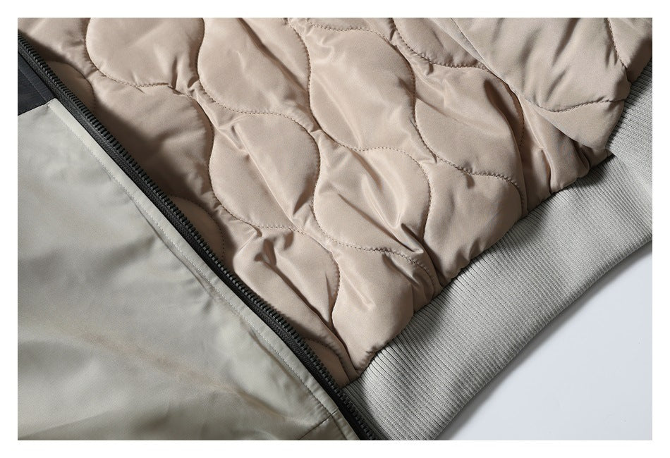 Close-up of beige quilted jacket lining, black zipper, and gray ribbed hem.