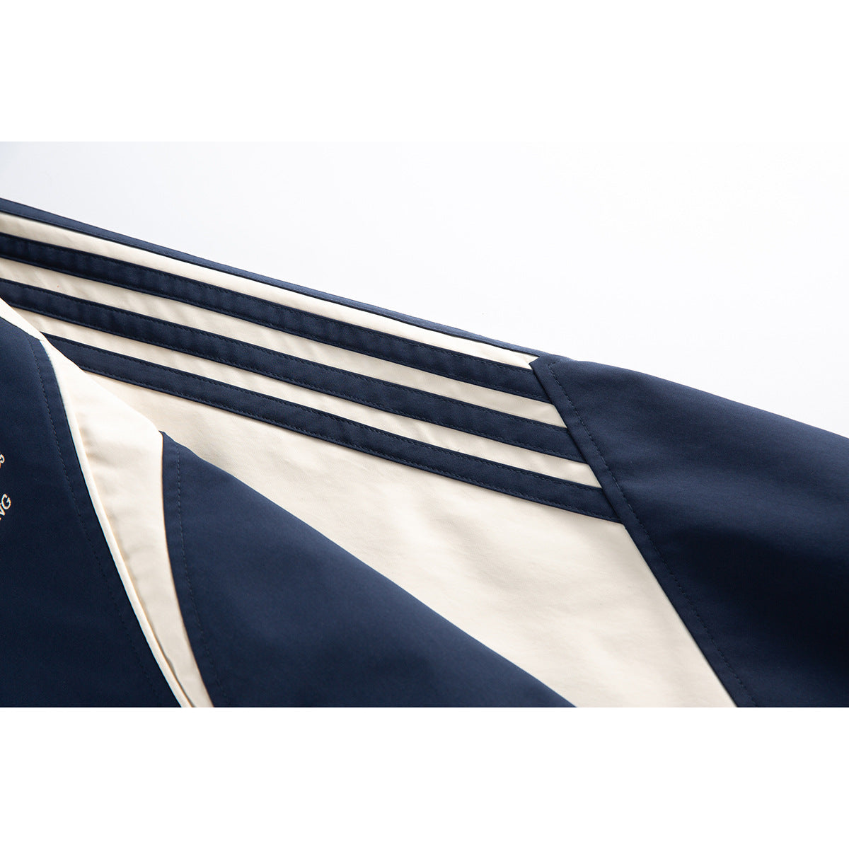 Close-up of cream-and-navy stripes running along the sleeve of a navy jacket.