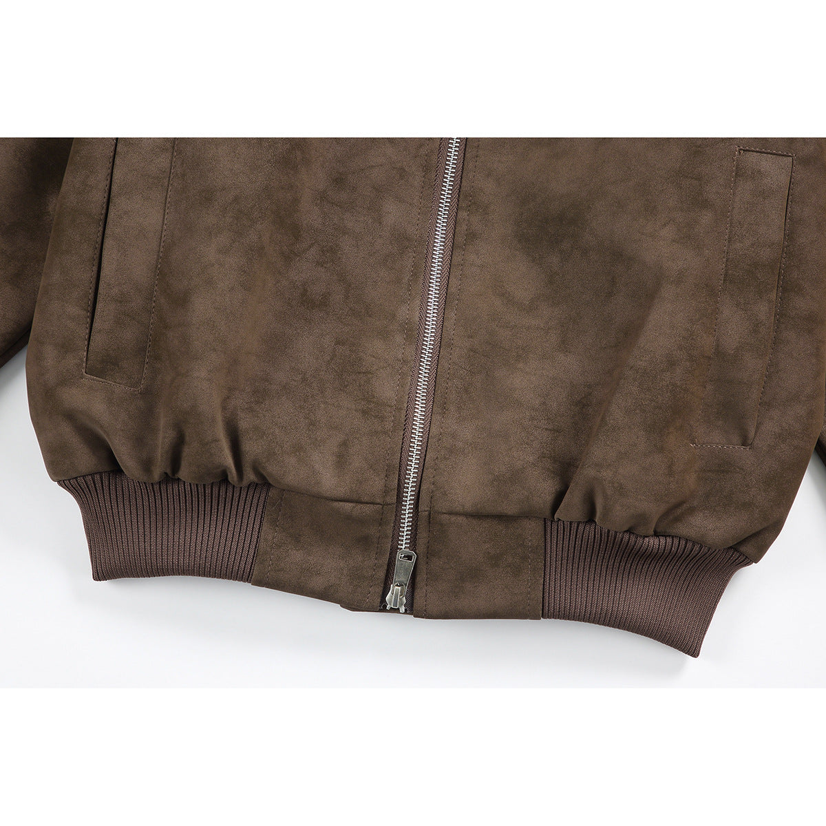 Close-up of the brown jacket's front zipper, side pockets, and ribbed hem.