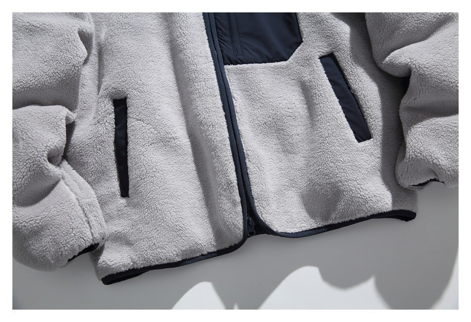 Close-up of the gray sherpa jacket’s navy-trimmed front zipper, chest pocket, and two slanted hand pockets.