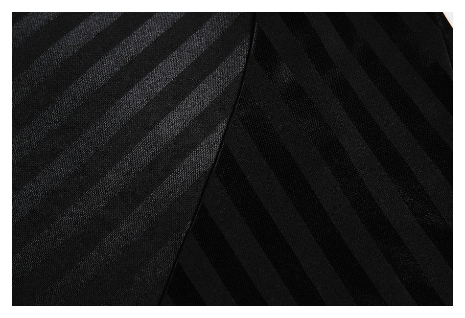 Close-up of black fabric with diagonal tonal stripes meeting along a curved seam.