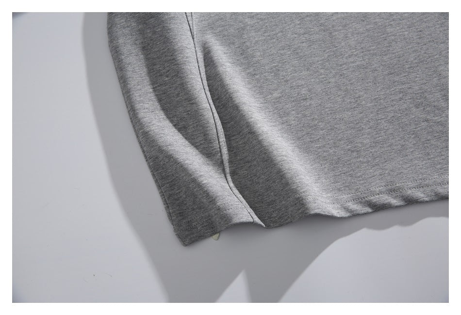 Close-up of a heather gray sweatshirt's sleeve and lower side seam.