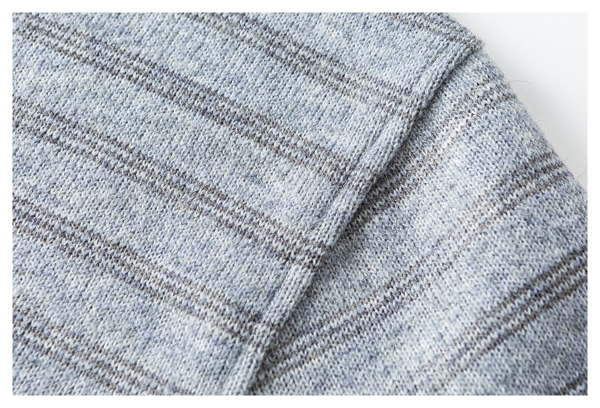 Close-up of a stitched seam on gray heathered knit fabric with narrow dark stripes.
