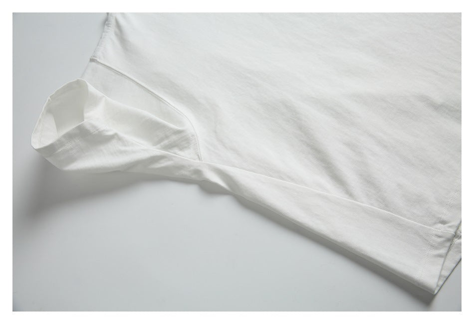 Close-up of a white T-shirt sleeve and underarm seam, laid flat.