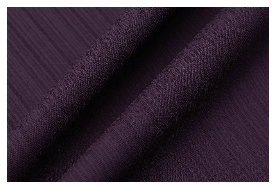 Close-up of dark plum ribbed fabric draped in soft folds.