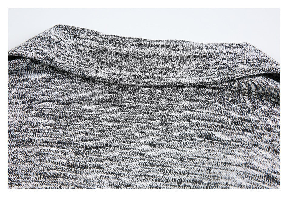 Close-up of the folded collar on a black, gray, and white marled knit garment.