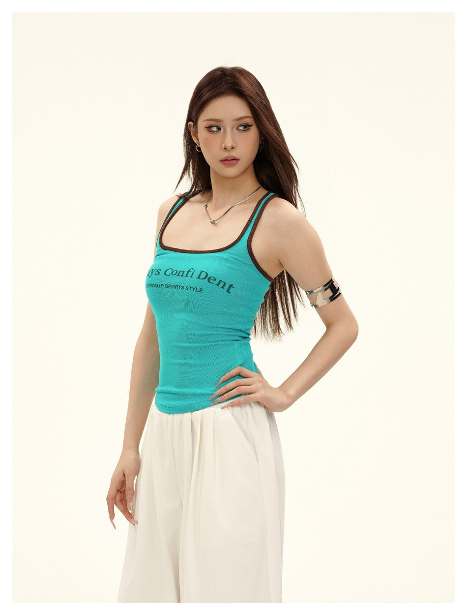 Three-quarter view of a model wearing a turquoise tank with dark trim and white pants.