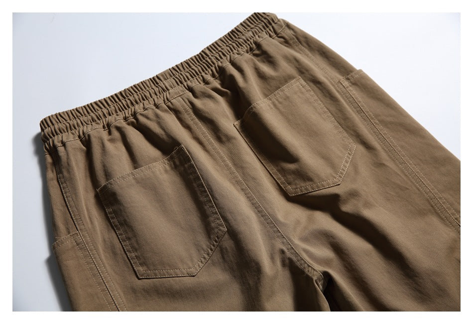 Back view detail of brown pants with a gathered elastic waistband and two patch pockets.