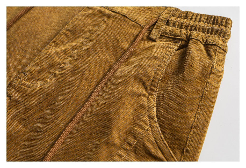 Close-up of a mustard-brown pant leg showing the side seam, pocket opening, and elastic waistband.