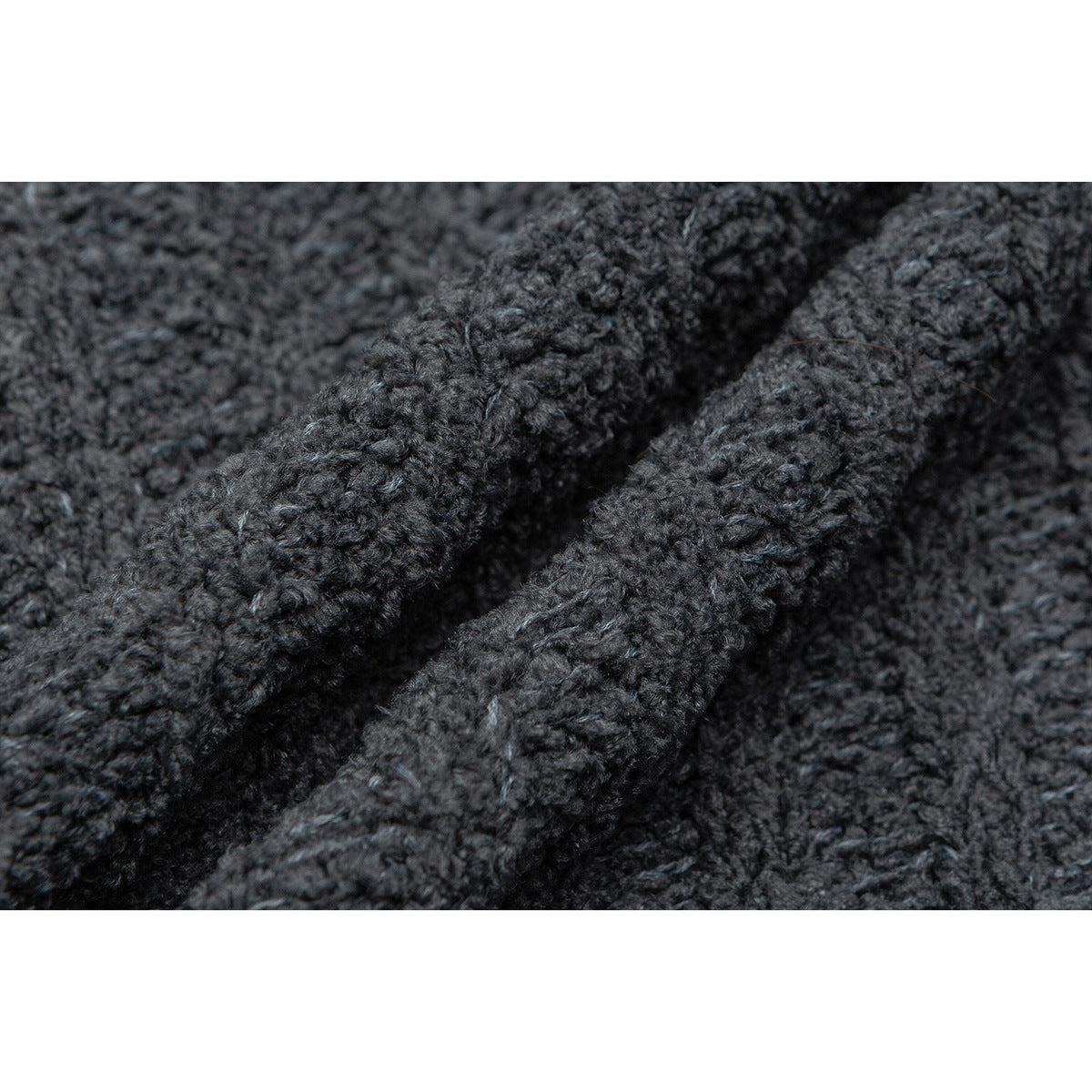 Extreme close-up of the dark charcoal cardigan's chunky knit texture.