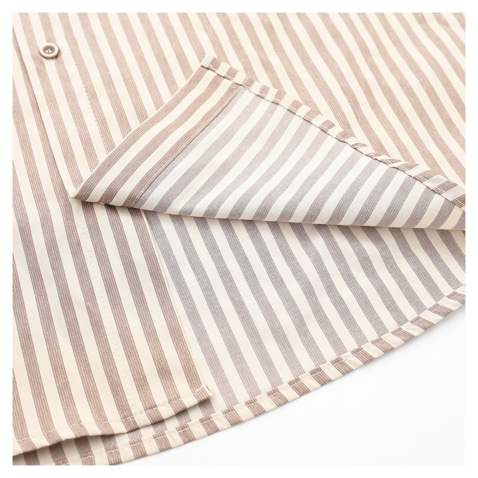 Close-up of a cream and taupe striped shirt with a folded section showing its stitching and hem.