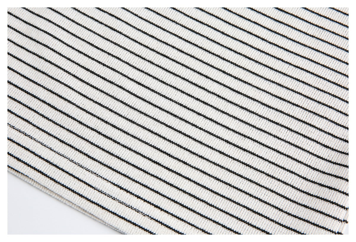 Close-up of cream knit fabric with evenly spaced thin black stripes.