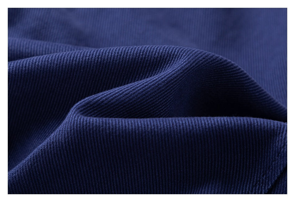 Macro view of the navy jacket fabric, showing its fine diagonal ribbed texture.