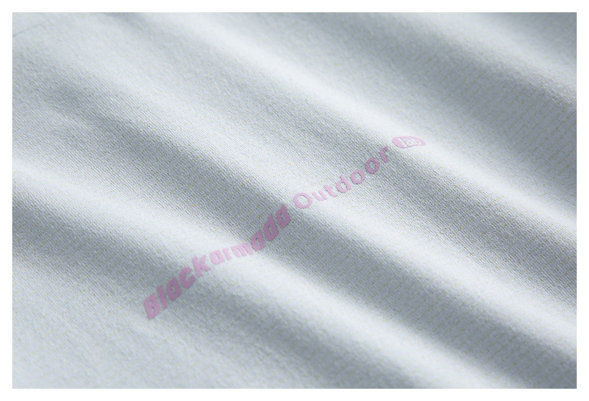 Close-up of pale fabric with a pink “Blockamodo Outdoor” print.