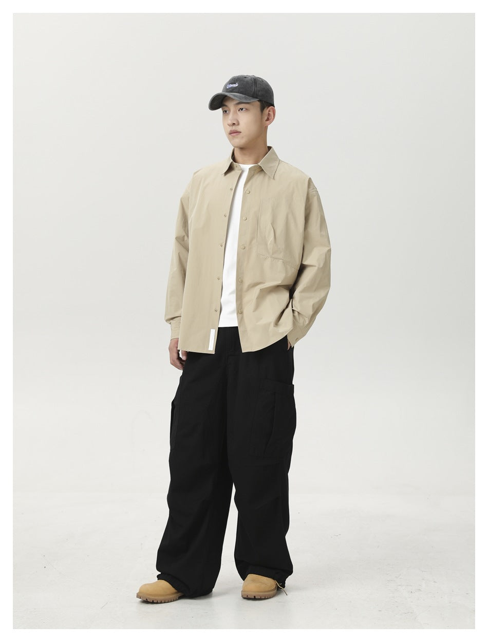 Model wearing black wide-leg cargo pants with a beige shirt, white tee, cap and tan boots