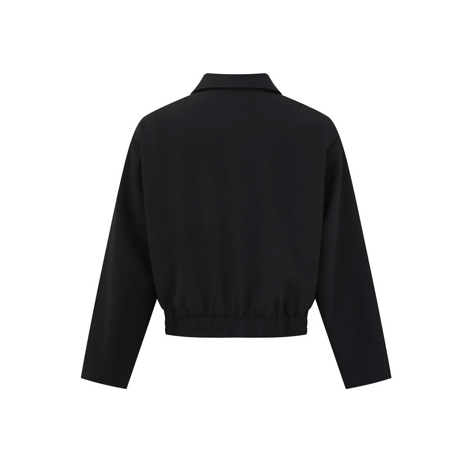 Back view of a black cropped jacket with a pointed collar, long sleeves, and an elasticated hem.