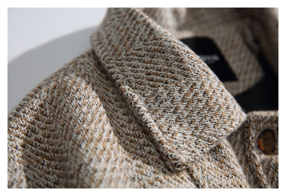 Close-up of the coat's wide tweed lapel and part of a brown button.