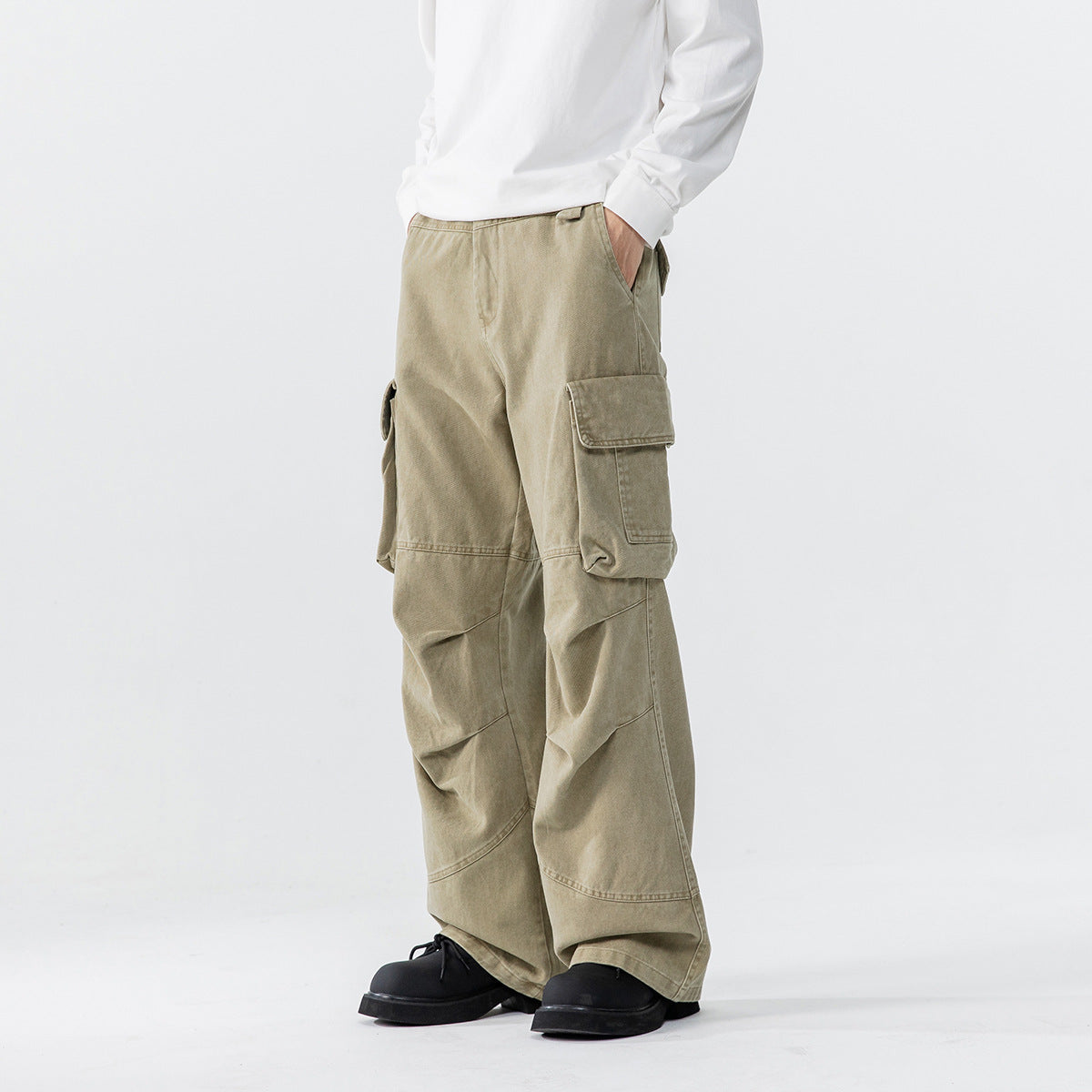 Model wearing light khaki wide-leg cargo pants with large flap pockets, shown from a three-quarter front angle.