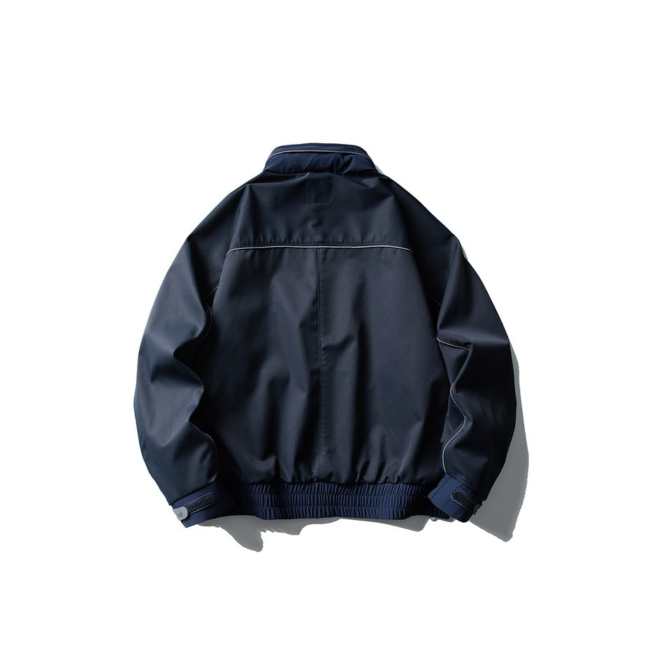 Back view of a navy jacket with a stand collar, curved shoulder seam and gathered elastic hem.